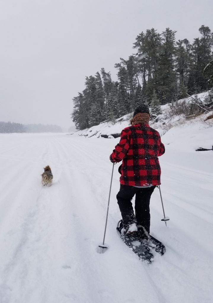 Leanne Fournier snowshoeing on the ice with snow and trees