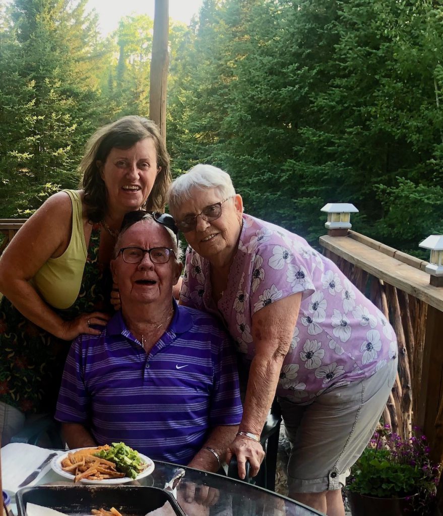 Two woman and a man around a table with food