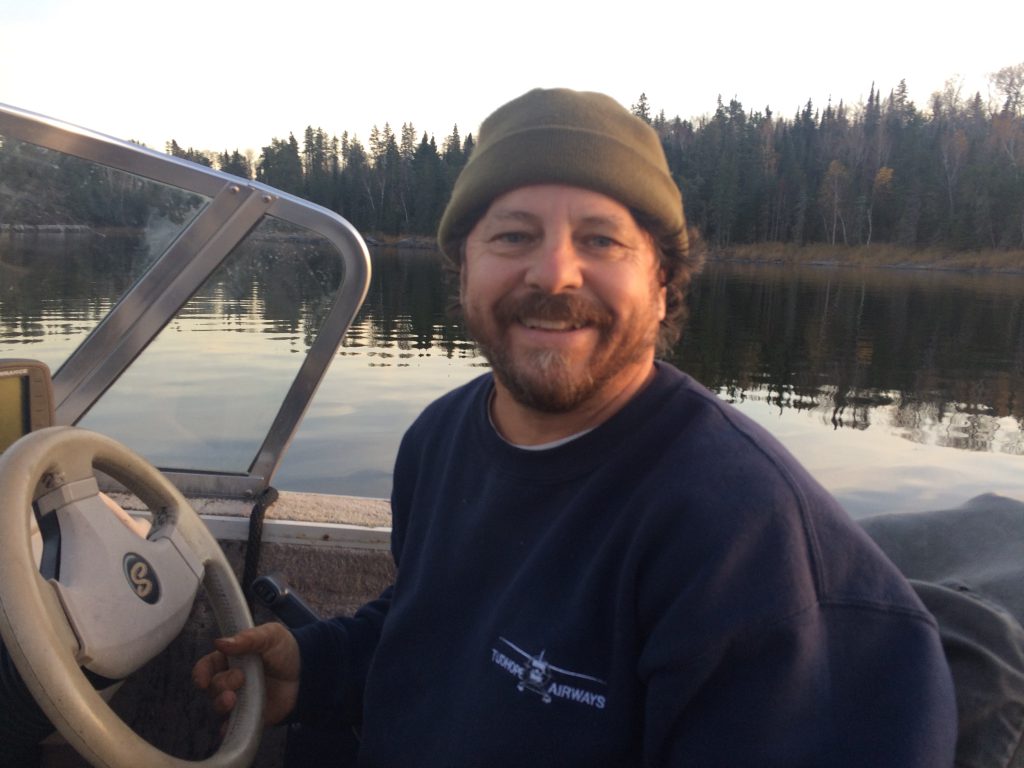 Michael Fournier in boat smiling at camera