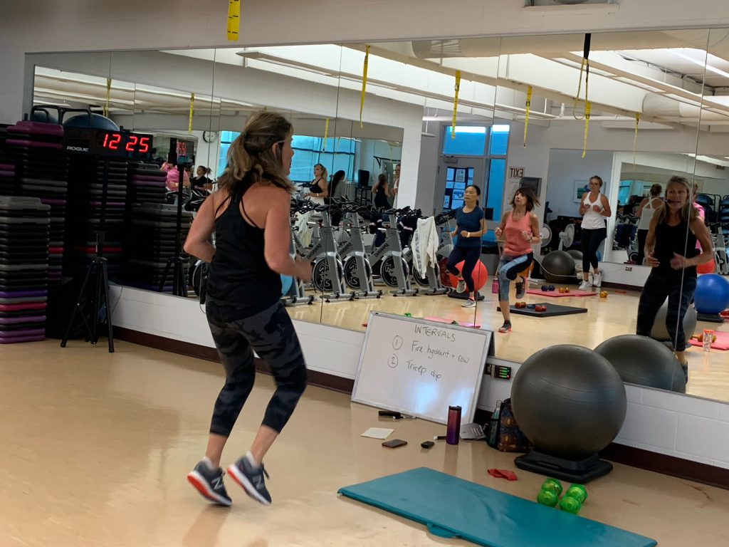 Fitness instructor Kelli Saunders starts her fitness class with some side step warmups.